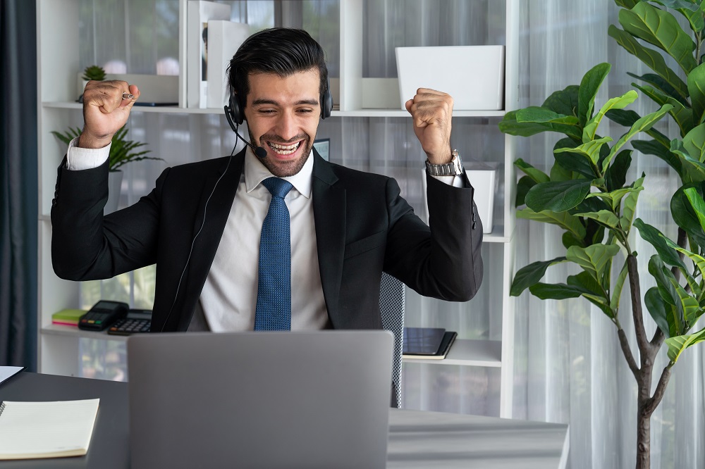 Positive sales leader using laptop