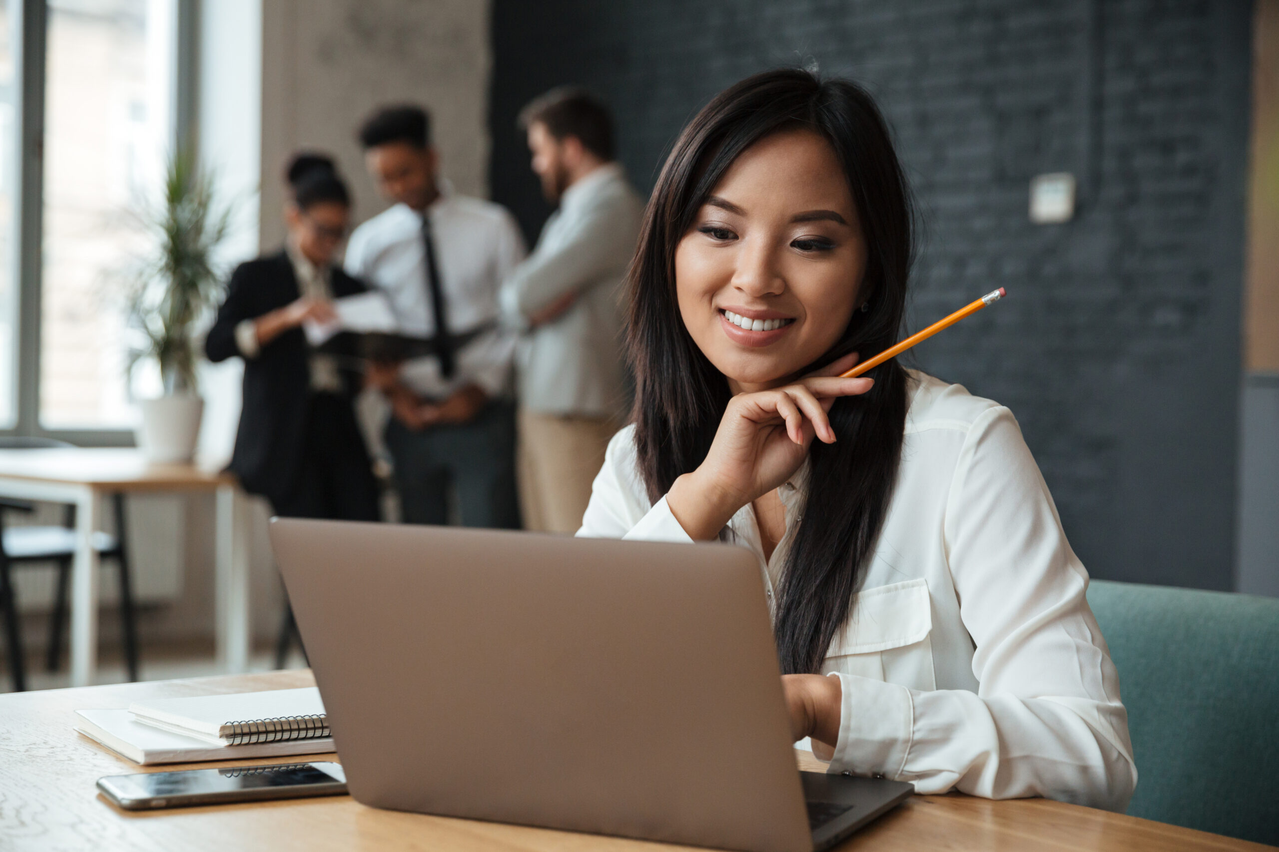 cheerful-young-asian-businesswoman-using-laptop cheerful young asian businesswoman using laptop